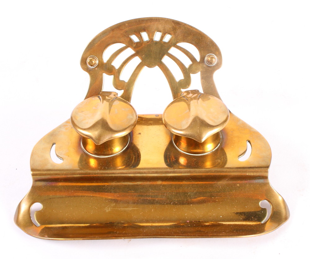 An Art Nouveau brass inkstand, fitted two ink wells and pen rest, 7" wide