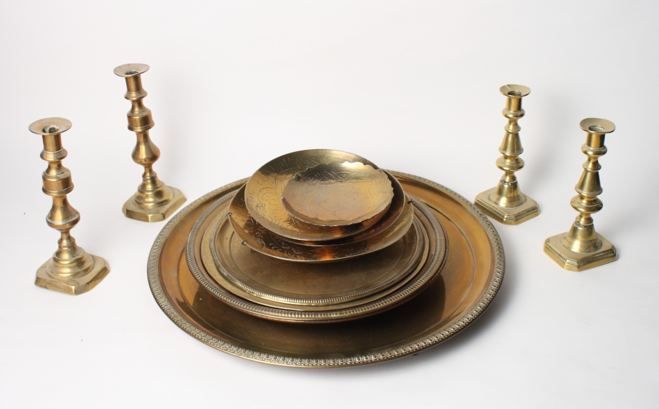 Two pairs of brass candlesticks and a number of brass trays