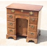 A George III mahogany kneehole desk, fitted one long and six small drawers with central cupboard, on