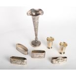 Two miniature sterling silver beakers, four white metal napkin rings and a Chinese silver trumpet