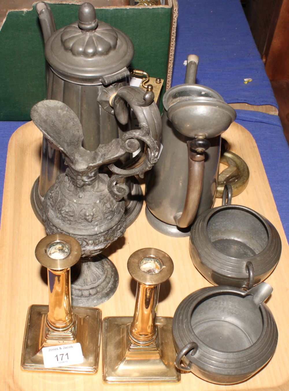 A pair of late Georgian brass candlesticks, two pewter coffee pots, a pewter sugar and cream set and