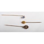 A gold stick pin set rose diamond and two other gold stick pins