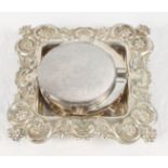 A square silver butter dish stand with repoussé floral and scroll decorated border, a pair of