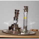 A pair of plated on copper candlesticks, a pair of similar candlesticks with transparent columns,