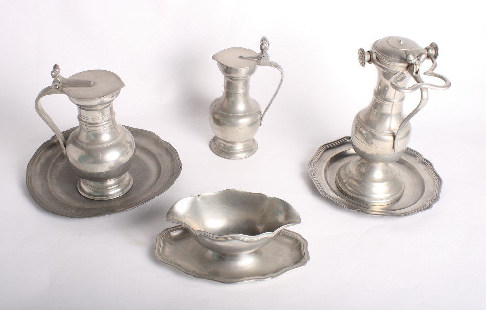 Three pewter tappit hens with acorn finials, a double-ended pewter sauce boat and other items of