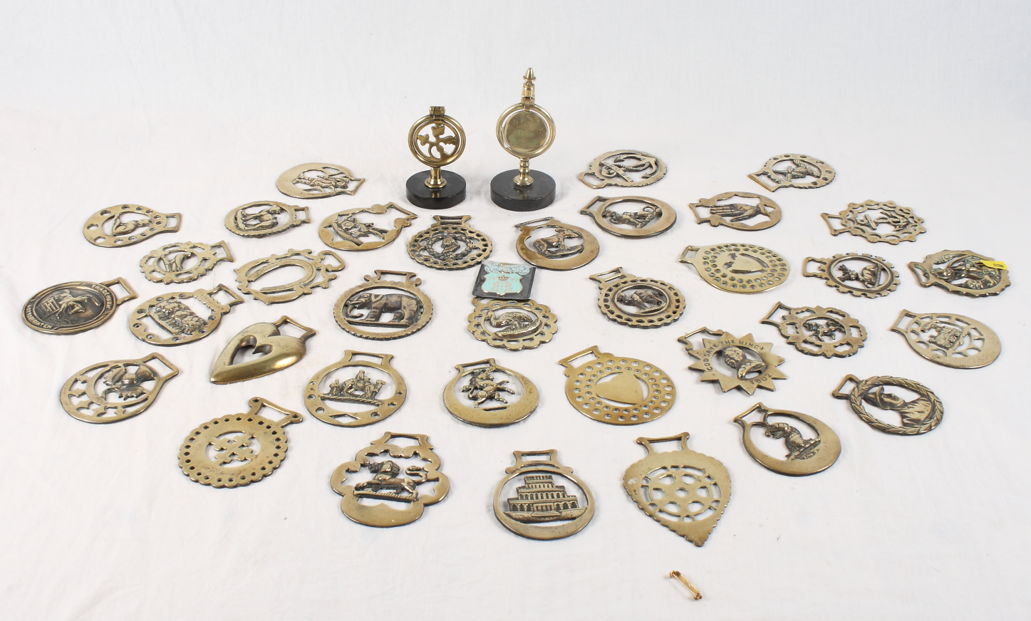 A collection of late 19th Century and early 20th Century horse brasses and two single top swingers