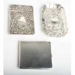 A repoussé decorated silver card case, an engine turned silver cigarette case and a similar