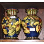 A pair of Doulton Lambeth stoneware vases decorated yellow leaves on a blue ground, potters mark for