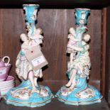 A pair of 19th Century Minton candlesticks decorated male and female figures holding children,