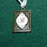 A gold and enamel decorated locket in the form of the Koran