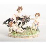 A continental porcelain model of three cherubs with a goat, 9" high