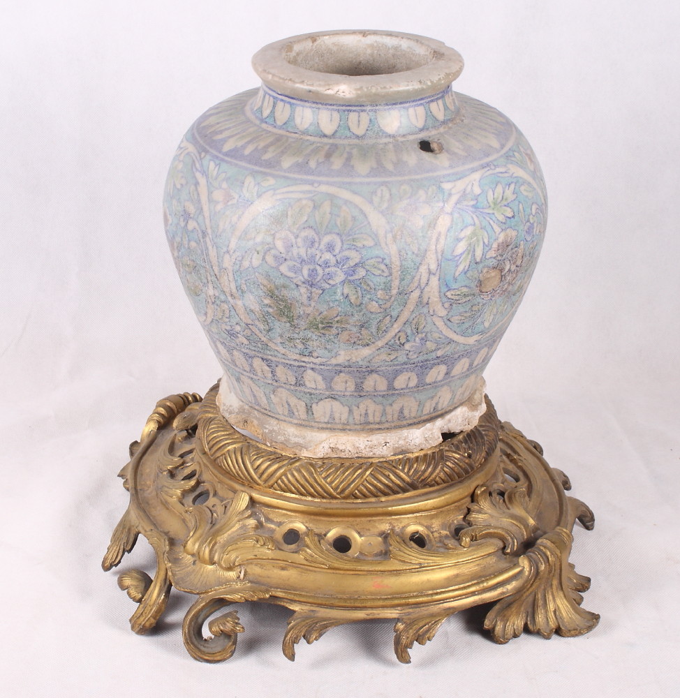 An Isnik pottery vase decorated in light and dark blue with circular floral panels, 10" high, with