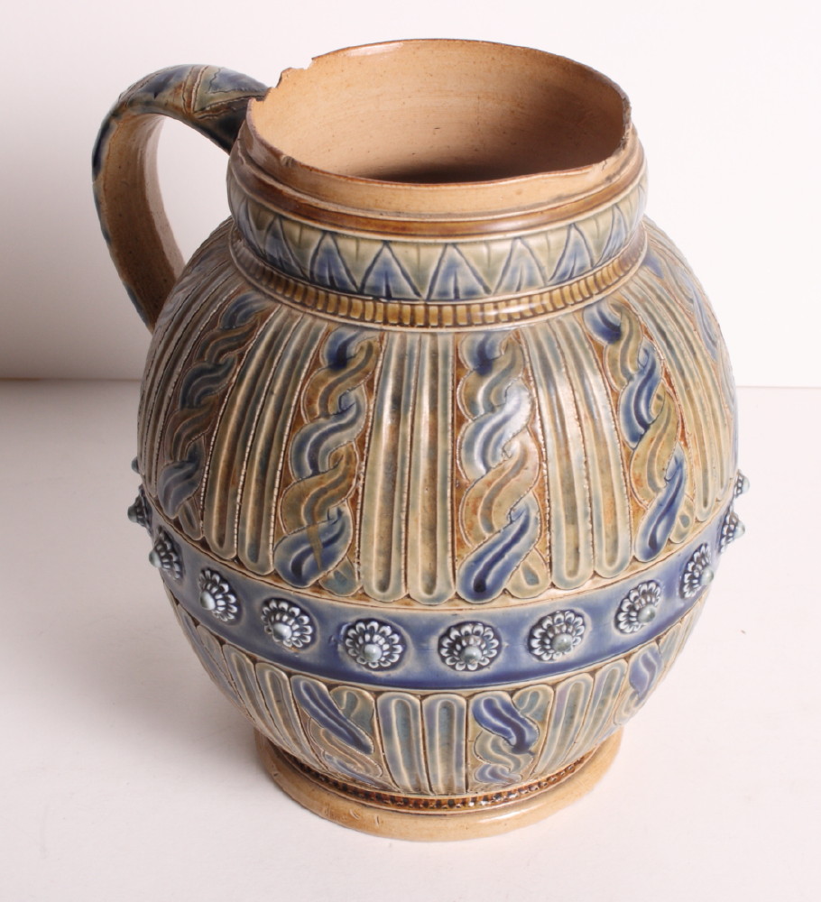 A Royal Doulton stoneware jug decorated in blue, brown and green glazes with panels of wrythen and