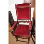 A 19th Century American rocking chair decorated spindle turning, upholstered in a red fabric