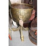 A circular engraved bulbous brass jardini?re on three cast dolphin supports, 16" high