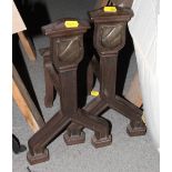 A pair of bronzed fire iron rests, finials decorated shields