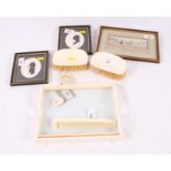 An ivory dressing table tray, two ivory backed clothes brushes, a miniature carved ivory frame and