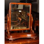 A Victorian mahogany framed toilet mirror on scroll standards and shaped platform base