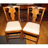 A set of four provincial oak standard dining chairs of Georgian design with shell carved splats