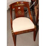 A pair of Empire design bucket seat dining chairs decorated gilt metal mounts, on sabre supports