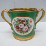 An oversized 19thC green ground  loving cup, hand painted with floral decoration, gilded handles and
