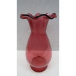 A large cranberry glass vase with wavy rim, 25cm.