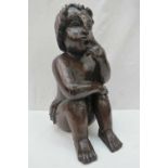 A carved limewood seated cherub. (Wings