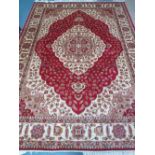 A red ground Kum carpet 280cm x 200cm.