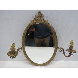 An oval bevel edged wall mirror mounted