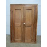 An early 20thC pine two door cupboard, d