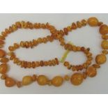 A graduated row of 'egg yolk' amber bead