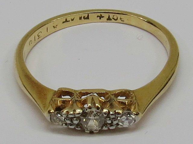 A diamond three stone ring, shank stampe