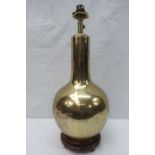 A weighty brass lamp on a wooden base, o