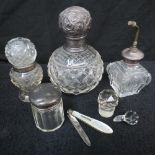 Four cut glass containers, each with a s