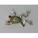 A cast white metal frog brooch set with