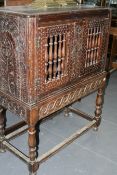 A 17TH.C.AND LATER CARVED OAK HUTCH CUPBOARD ON STAND