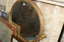 A GILT FRAMED OVAL MIRROR