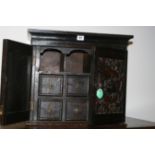 AN ANTIQUE OAK TABLE CABINET WITH CARVED DOORS