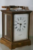 AN EDWARDIAN BRASS CASED CARRIAGE CLOCK WITH ENAMEL DIAL SIGNED H & W BIRD