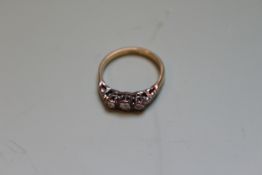 AN 18CT.GOLD AND DIAMOND THREE STONE RING.   £100-200