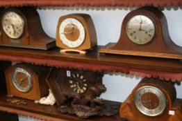 A BLACK FOREST CARVED CUCKOO WALL CLOCK TOGETHER WITH FIVE ART DECO AND LATER MANTLE CLOCKS