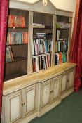 A BESPOKE PAINT DECORATED BREAKFRONT LIBRARY BOOKCASE