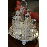 A SILVER PLATED SIX BOTTLE CRUET SET TOGETHER WITH A DECANTER CARRIER