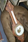 A LATE VICTORIAN CARVED OAK ANEROID BANJO BAROMETER WITH THERMOMETER SIGNED FENN, WEMBLEY
