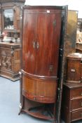 A REGENCY MAHOGANY BOW FRONT CORNER CABINET