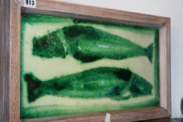 AN ART POTTERY PLAQUE DECORATED WITH STYLISED FISH