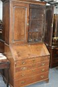 A LATE 18TH.C.OAK BUREAU BOOKCASE WITH PANEL DOORS