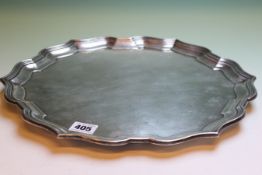 A SILVER SALVER WITH SHAPED STEPPED RIM ON BUN FEET, DATED B'HAM 1929, 36cms DIAMETER, APPROX 36ozs.