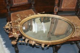 A VICTORIAN GILT FRAMED OVAL MIRROR WITH SWAG DECORATION