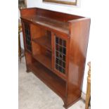 AN ARTS AND CRAFTS BOOKCASE WITH LEAD GLASS DOORS